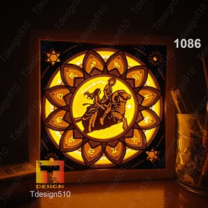 May include: A white wooden frame with a lit-up image of a zodiac sign, Aries, with a couple riding a ram. The image is surrounded by a circle of other zodiac signs. The frame is illuminated from behind, casting a warm glow.