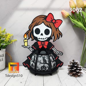 May include: A Halloween lantern with a skeleton girl design. The girl has brown hair, a red bow, and holds a candle. The black lantern features a cat and pumpkin design. The number 3062 is visible.