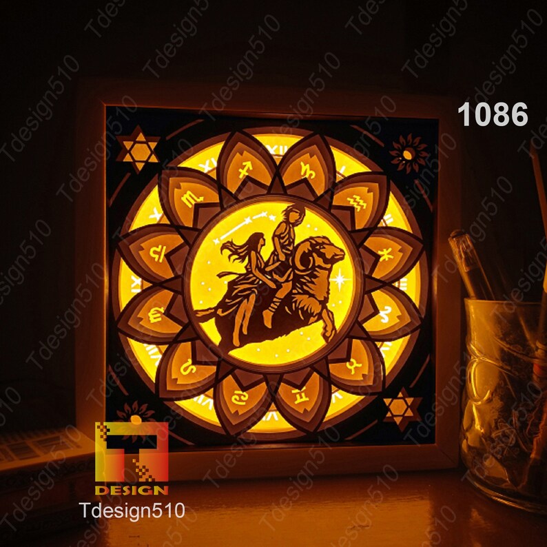 May include: A white wooden frame with a lit-up image of a zodiac sign, Aries, with a couple riding a ram. The image is surrounded by a circle of other zodiac signs. The frame is illuminated from behind, casting a warm glow.