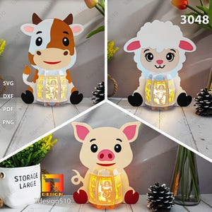 Puede incluir: Tres faroles decorativos con forma de animales: una vaca, una oveja y un cerdo. Cada farol tiene un diseño recortado que brilla con una luz interna. La vaca es marrón y blanca, la oveja es blanca y el cerdo es rosa. Los faroles están etiquetados con "SVG, DXF, PDF, PNG".