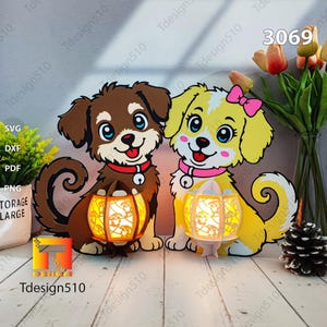 May include: Two cartoon dog cutouts, one brown and one yellow, each holding a glowing lantern. The brown dog has a red collar, and the yellow dog has a pink bow and collar. The image includes the text "Tdesign510" and "3069".