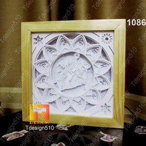 May include: A white papercraft 3D art piece in a wooden frame. The design features a zodiac symbol with a constellation and a flower-like design around it. The zodiac symbol is Sagittarius.