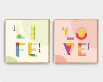 May include: Two framed prints with geometric designs spelling out the words "LIFE" and "LOVE". The "LIFE" print has a green background with the text "HAPPY MIND" and the word "HAPPY" above the letter "L". The "LOVE" print has a pink background with the text "I'M IN LOVE WITH YOU" and the words "I'M IN" above the letter "L".