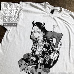 Könnte beinhalten: Weißes T-Shirt mit einer schwarz-weißen Illustration im Anime-Stil eines Charakters mit Hörnern, Kapuzenmantel und Schwanz. Der Text "EELS AND BRO ON ETSY" ist auf das T-Shirt gedruckt.