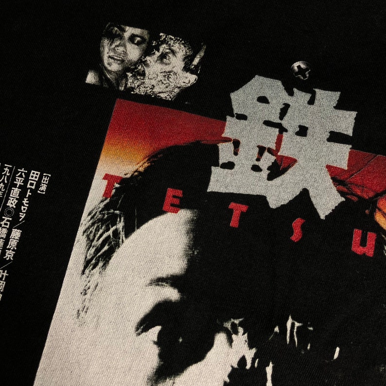 Puede incluir: Camiseta negra con un dise&ntilde;o gr&aacute;fico que presenta la palabra "TETSU" en caracteres japoneses rojos y blancos. El dise&ntilde;o incluye un retrato y texto japon&eacute;s. La camiseta tiene una est&eacute;tica vintage.