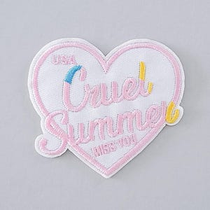 Könnte beinhalten: Gestickter Aufnäher in Herzform mit dem Schriftzug "Cruel Summer" in rosa Schrift, mit gelben und blauen Akzenten. Das Wort "USA" steht oben. Der Satz "Miss You" steht unten. Weißer Hintergrund.