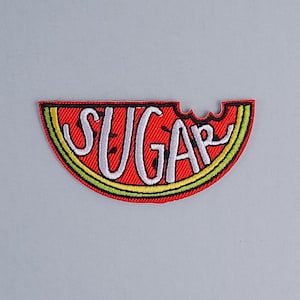 Può includere: Toppa ricamata a ferro rosso e verde a forma di fetta di anguria con la parola "SUGAR" in lettere bianche.