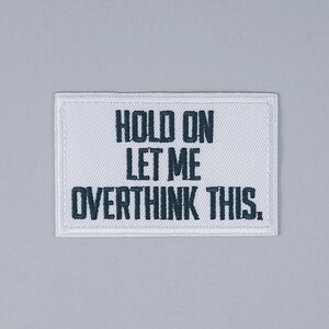 May include: White fabric patch with black embroidered text that reads "Hold on let me overthink this."