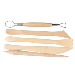 May include: A set of five light-colored wooden pottery tools. The tools include a loop tool, a flat tool, a serrated tool, a knife-shaped tool, and a pointed tool. The tools are designed for sculpting and shaping clay.