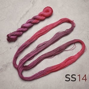 Op de afbeelding: Een klosje roze en paarse ombre borduurgaren, met de tekst "SS14" eronder gedrukt.