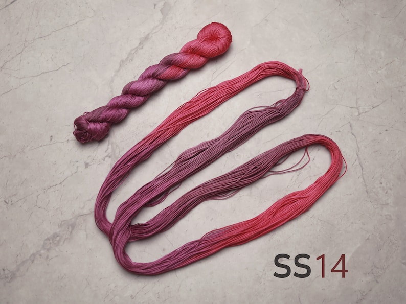 Op de afbeelding: Een klosje roze en paarse ombre borduurgaren, met de tekst "SS14" eronder gedrukt.