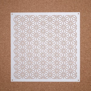 Op de afbeelding: Witte sjabloon met een geometrisch patroon van herhalende sterren. De sjabloon is gemaakt van dun, duurzaam materiaal en heeft een gladde, witte afwerking.