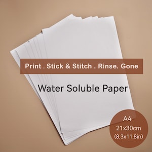 Può includere: Una pila di fogli di carta A4 solubile in acqua bianca. La carta misura 21x30cm. Il testo sull'immagine recita "Print. Stick & Stitch. Rinse. Gone" e "Water Soluble Paper".