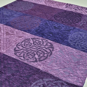 May include: Purple and blue patterned scarf with a fringe. The scarf has a tag that says "Calzeat Celtic Collection".