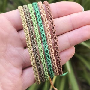 Puede incluir: Una taza de cerámica blanca con un asa negra y el texto "But First, Coffee" en negrita negra. La taza está sobre un fondo borroso. La taza mide aproximadamente 10 cm de altura.