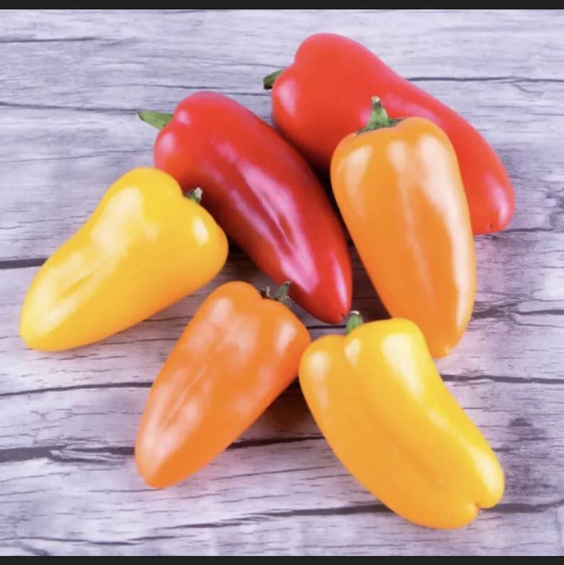 May include: Five bell peppers, two yellow, two orange, and one red, arranged on a wooden surface.