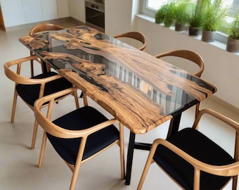 Op de afbeelding: Een houten eettafel met een zwarte epoxyhars inlay. De tafel heeft een natuurlijke houtkleur en is omringd door zes stoelen met zwarte kussens.