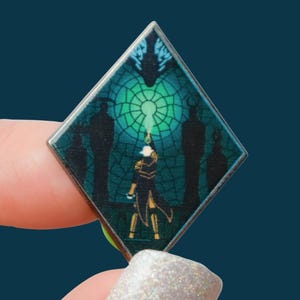 Könnte beinhalten: Ein rautenförmiger Emaille-Pin mit einer Fantasy-Szene. Eine Figur greift nach einem leuchtenden grünen Schlüsselloch, mit Silhouetten im Hintergrund. Das Design hat einen teal- und grünen Glasmalerei-Effekt und einen silbernen Metallrand.