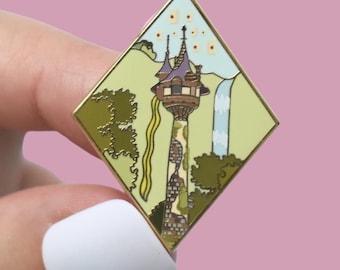 Könnte beinhalten: Ein rautenförmiger Emaille-Pin mit goldenem Rand, der einen Zeichentrickturm mit lila Dach, Wasserfall und langem blondem Haar darstellt. Der Hintergrund ist hellgrün und blau. Ein dekoratives Accessoire.
