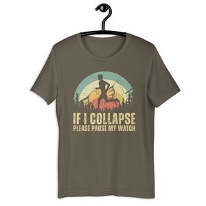 May include: A brown t-shirt with a vintage-style graphic of a runner in front of a mountain range. The text "IF I COLLAPSE PLEASE PAUSE MY WATCH" is printed below the graphic.