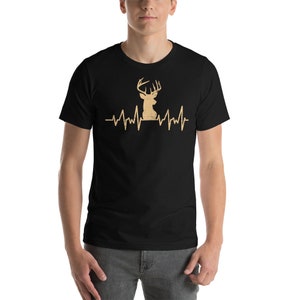 May include: A black t-shirt with a gold deer silhouette and a heartbeat graphic. The deer has antlers and is facing left. The graphic says "My Heart Beats for Deer".