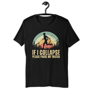 May include: Black t-shirt with a vintage-style graphic of a runner in front of mountains. The text "IF I COLLAPSE PLEASE PAUSE MY WATCH" is printed below the graphic.