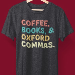 Pode incluir: Uma camiseta cinza escura com o texto "COFFEE, BOOKS, & OXFORD COMMAS." impresso em letras retrô coloridas.