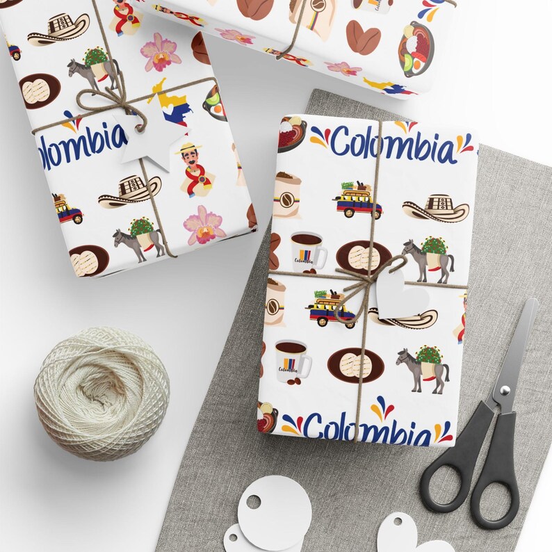 May include: White wrapping paper with a repeating pattern of Colombian cultural icons, including coffee cups, hats, and donkeys carrying goods. The word "Colombia" is written in blue. Tied with twine.