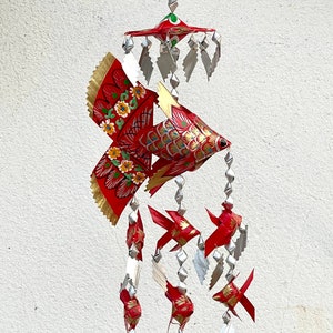 Mini red Thai woven fish mobile made from palm leaf with colorful patterns.