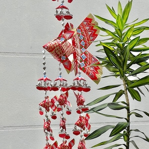 Thai red fish mobile weaved with palm leaves painted bright gold . It’s a handmade weave work as a decoration.