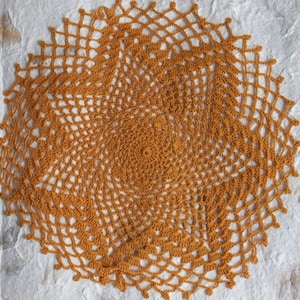 Coasters and saucers It is a work of crocheting with brown thread. It is a delicate and beautiful handicraft.