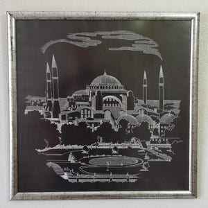 May include: A black and white line drawing of the Hagia Sophia mosque in Istanbul, Turkey. The drawing is framed in a silver frame.