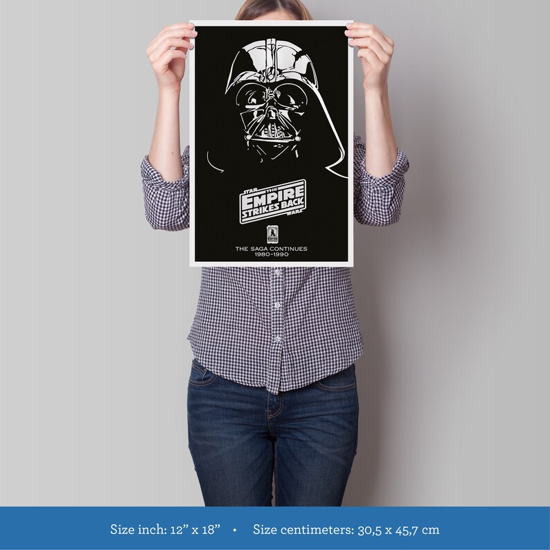K&ouml;nnte beinhalten: Ein Schwarzwei&szlig;-Poster mit Darth Vader aus dem Film Star Wars: Das Imperium schl&auml;gt zur&uuml;ck. Der Text auf dem Poster lautet "Star Wars: Das Imperium schl&auml;gt zur&uuml;ck" und "Die Saga geht weiter 1980-1990". Das Poster ist 30,5 Zentimeter mal 45,7 Zentimeter gro&szlig;.