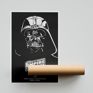 K&ouml;nnte beinhalten: Ein Schwarzwei&szlig;-Poster mit Darth Vader aus Star Wars: Das Imperium schl&auml;gt zur&uuml;ck. Der Text "STAR WARS: DAS IMPERIUM SCHL&Auml;GT ZUR&Uuml;CK" befindet sich am unteren Rand des Posters, zusammen mit dem Text "DIE SAGA GEHT WEITER 1980-1990".