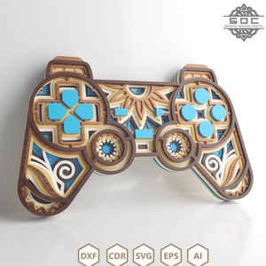 May include: A wooden laser cut gamepad with intricate geometric patterns in brown, blue, and white. The gamepad has a mandala design in the centre and blue buttons.
