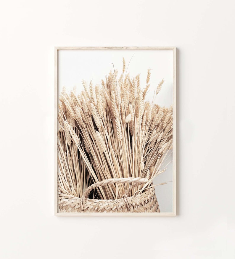 May include: A close-up of a woven basket filled with dried wheat stalks. The basket is made of natural materials and has a rustic, earthy feel. The wheat stalks are a light beige color and are arranged in a loose, organic pattern.