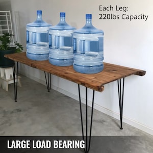 May include: Three large clear water bottles on a wooden table with black hairpin legs. The table is labeled "LARGE LOAD BEARING" and "Each Leg: 220lbs Capacity".