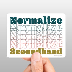 May include: A sticker with the text "Normalize Secondhand" in a bold, layered font. The word "Normalize" is repeated multiple times in a gradient of teal, pink, and red. The word "Secondhand" is in a gold color.
