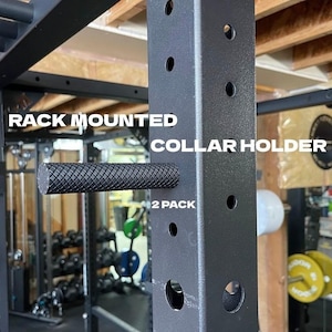 May include: Black rack mounted collar holder with a textured rubber grip. The text "RACK MOUNTED COLLAR HOLDER 2 PACK" is printed on the holder.