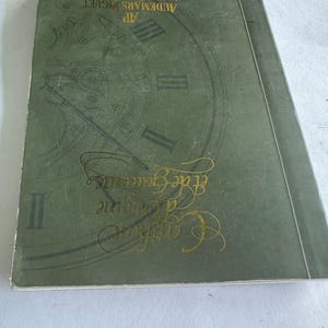 Peut inclure: Un livre vert avec des lettres dorées qui disent "Audemars Piguet AP" et "The Art of Excellence". La couverture présente un cadran d'horloge stylisé.