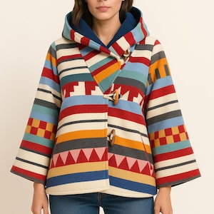 May include: A colorful hooded coat with a striped pattern in red, blue, yellow, and gray. The coat has wooden toggle closures and a blue interior lining. The sleeves are wide, and the coat is worn with blue jeans.