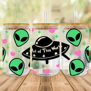 May include: Three clear plastic tumblers with bamboo lids and straws. Each tumbler features a different design with green alien heads, pink hearts, and a black UFO with the text "Out of This World".