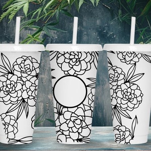 May include: Three white reusable cups with black floral designs and black straws. The cups have lids and are arranged in a row on a wooden surface.