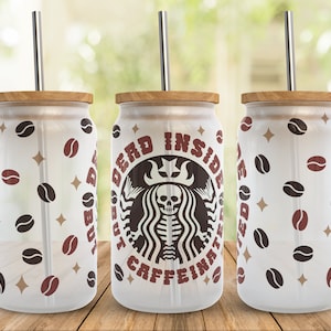 May include: Three white tumblers with lids and straws. The tumblers have a pattern of brown coffee beans and gold stars. The middle tumbler has a black and white graphic of a skeleton with a crown and the text "Dead Inside But Caffeinated".