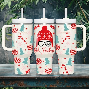 May include: Three stainless steel insulated tumblers with white handles and lids. The tumblers feature a festive design with candy canes, Christmas trees, and the text "Oh, Fudge". The tumblers are decorated with red, white, and blue accents.