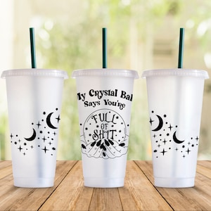 May include: Three clear plastic cold cups with lids and green straws. The cups have black celestial designs of moons and stars. One cup has the text "My Crystal Ball Says You're Full of Shit" in a black graphic.
