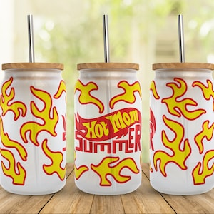 May include: Three white stainless steel tumblers with a wood lid and a straw. The tumblers have a red and yellow flame design with the text "Hot Mom Summer" on one of the tumblers.