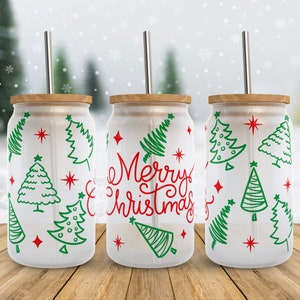 May include: Three white tumblers with green and red Christmas tree designs and the words "Merry Christmas" on one of the tumblers. Each tumbler has a bamboo lid and a stainless steel straw.