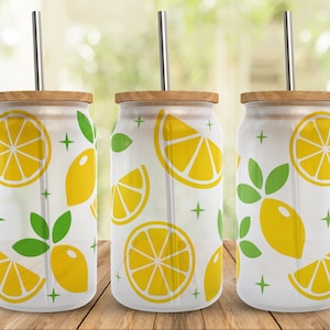 May include: Three white tumblers with a lemon and leaf pattern. Each tumbler has a straw and a wooden lid.