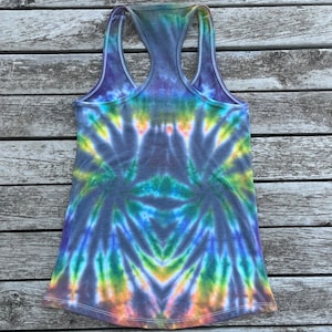 K&ouml;nnte beinhalten: Ein Batik-Tanktop mit einem Regenbogenmuster in Blaut&ouml;nen, Gr&uuml;n, Gelb und Orange. Das Tanktop ist aus einem weichen, bequemen Stoff gefertigt und hat einen Racerback-Stil. Das Tanktop ist in Gr&ouml;&szlig;e S erh&auml;ltlich.